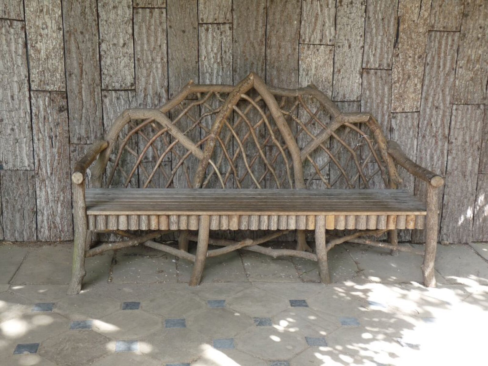 Rustic wooden bench made from branches in a root arbour