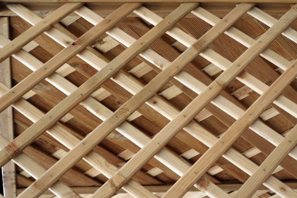 Close-up of a new pressure-treated softwood diamond lattice garden trellis panel