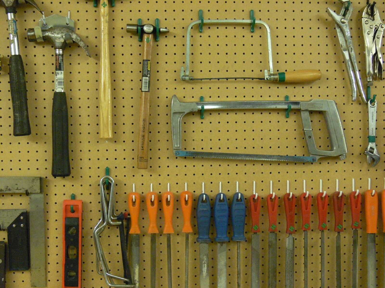 Hand tools hung on a pegboard wall